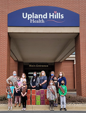 Girl Scout Troop pictured with Upland Hills Health nurses and donated cookies